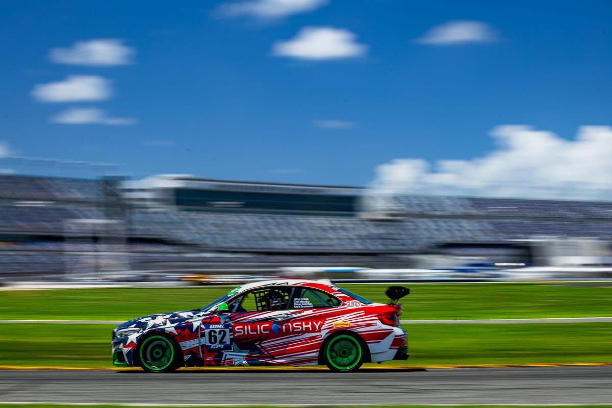 The number 62 BMW M235iR at speed, side profile